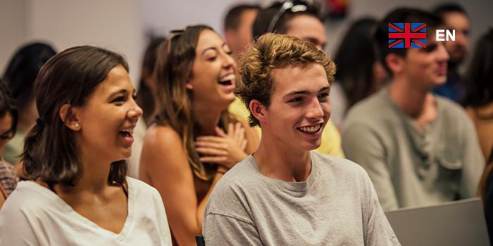 dos estudiantes en el auditorio sonriendo