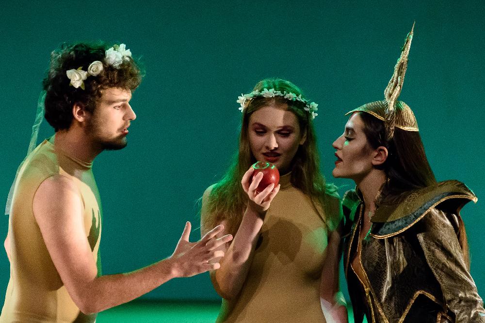 Actores en escena con una manzana