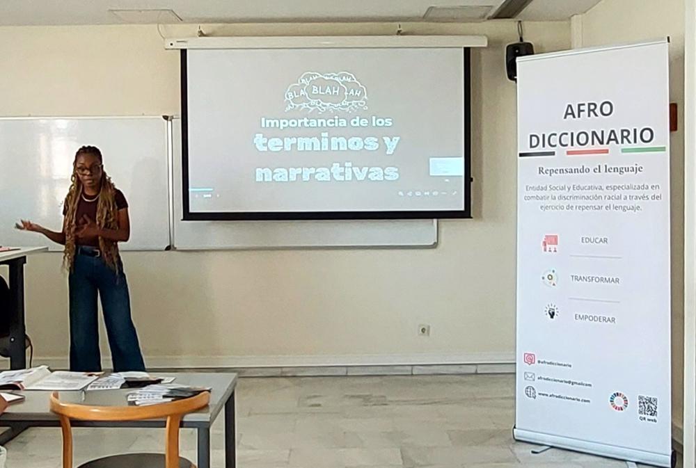 Una ponente impartiendo el curso junto a una pantalla de proyección