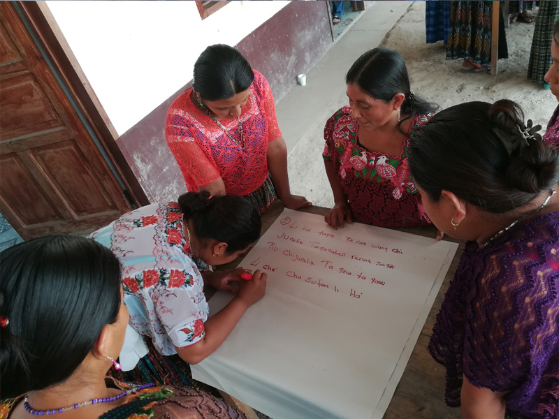 mujeres indígenas escribiendo conclusiones juntas