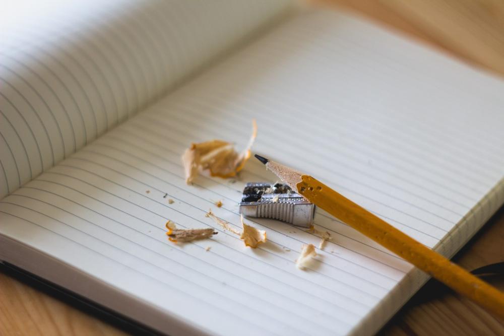Fotografía de un cuaderno, un sacapuntas y un lapicero