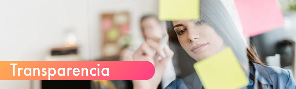 Tres compañeros de trabajo sonriendo mientras revisan un documento, con la palabra