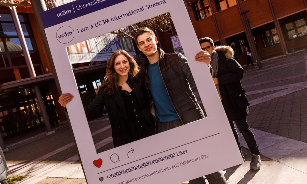 Dos estudiantes posan para la cámara con un cartón, que imita el diseño de una foto en Instagram