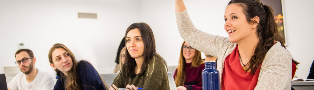 Alumna levantando mano en clase