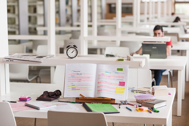 Libro y útiles de estudio encima de la mesa de la biblioteca