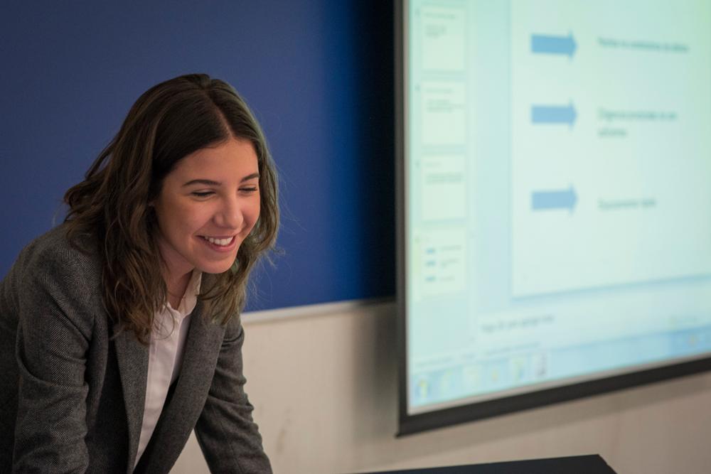 Alumna sonriendo durante una presentación en clase