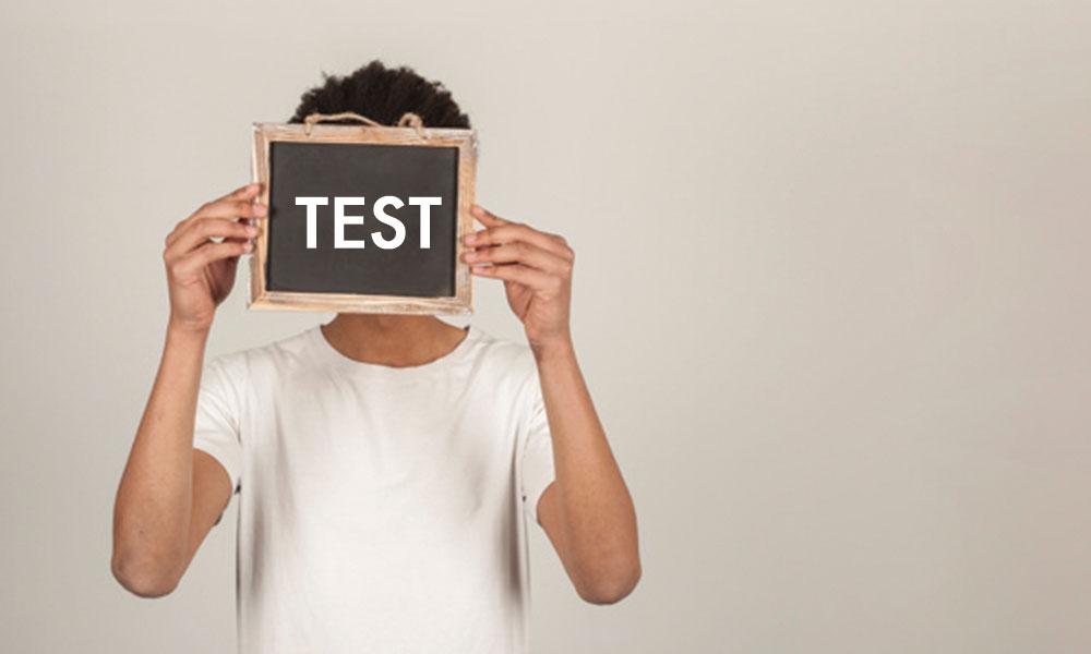estudiante con una pizarra donde se lee la palabra Test