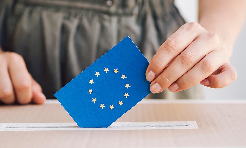 Mujer echando un voto con la bandera de la unión europea