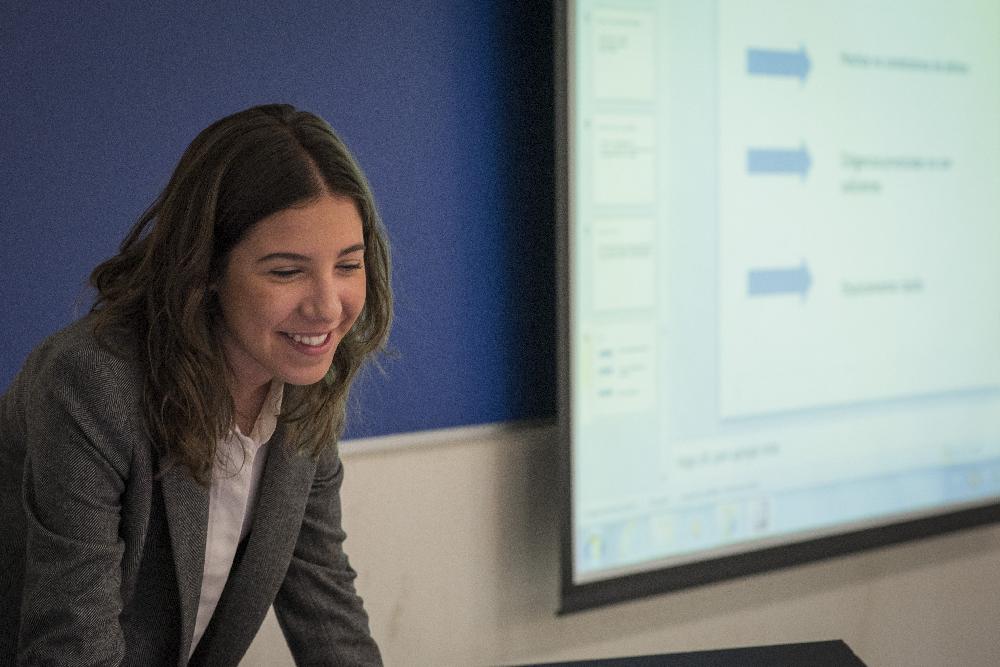 Alumna sonriendo durante una presentación en clase
