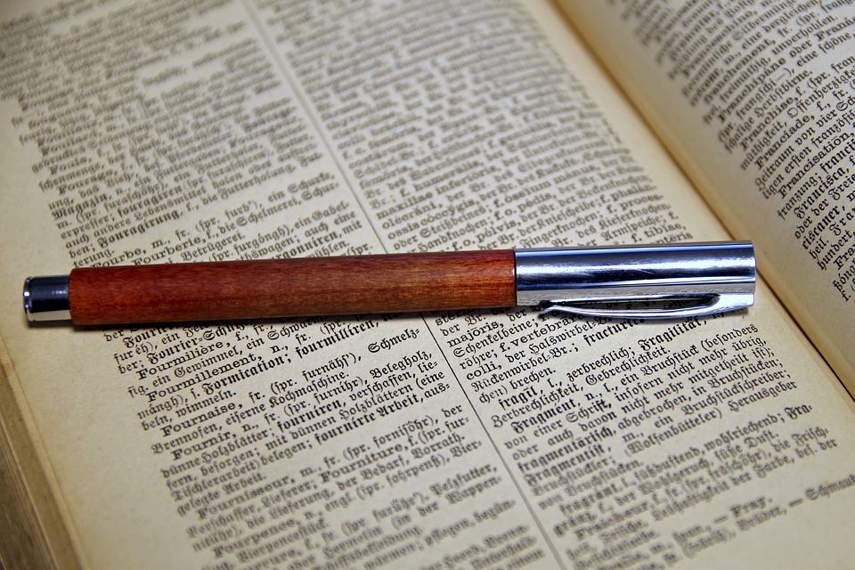 Fotografía de un libro y una pluma