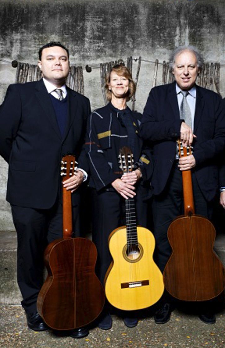 Fotografía de tres personas posando con guitarras.