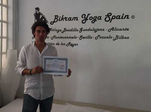 jonathan martin sujetando certificación como profesor de Bikram Yoga