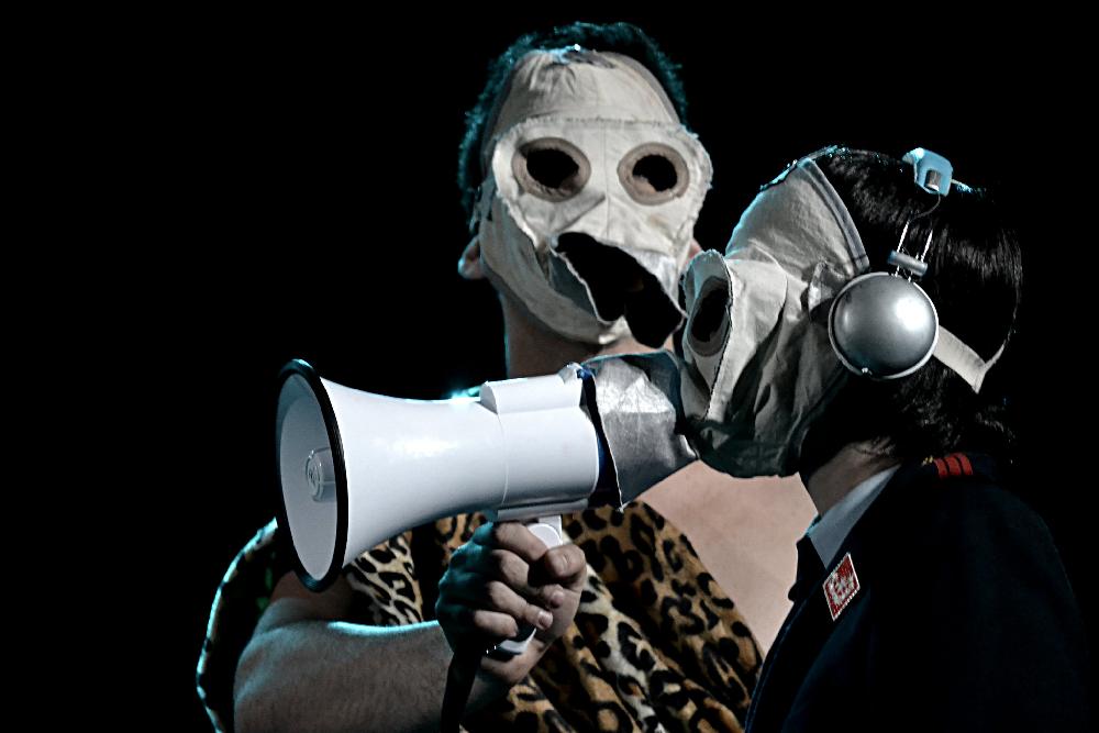 Dos actores con máscara y megáfono