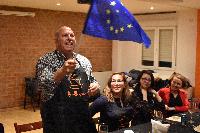 Foto de u hombre explicando con una bandera de la UE de fondo