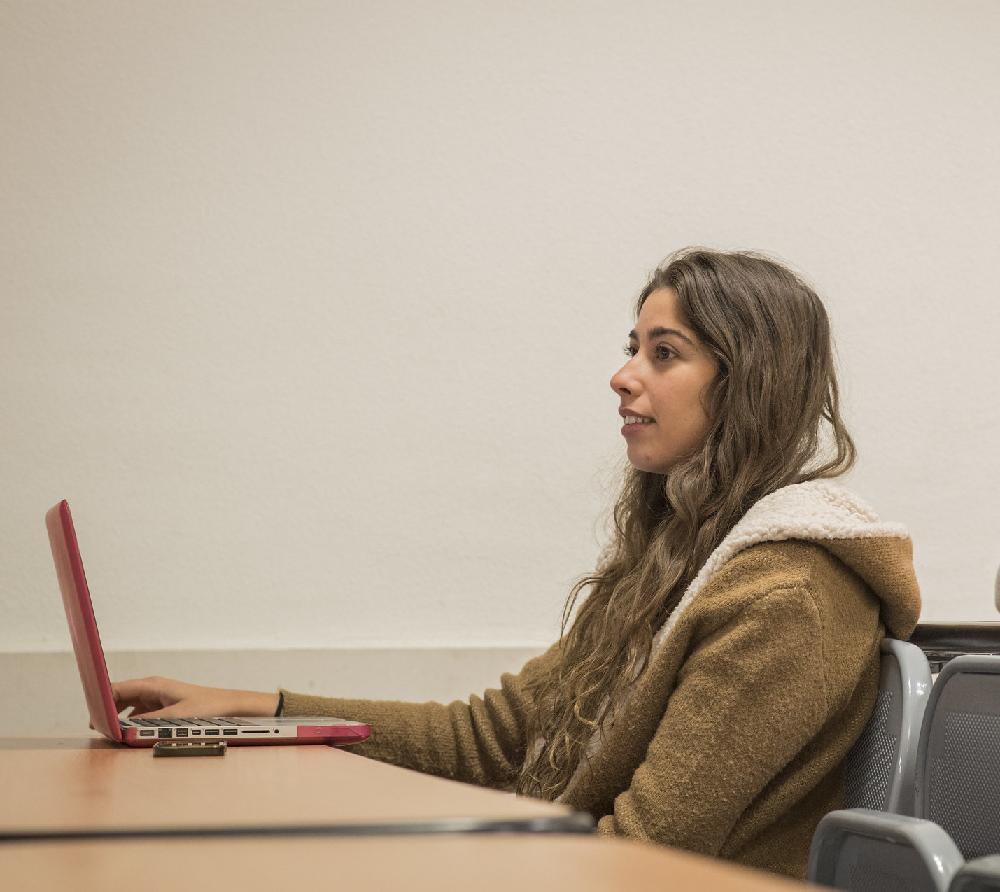 Estudiante en clase sola con ordenador