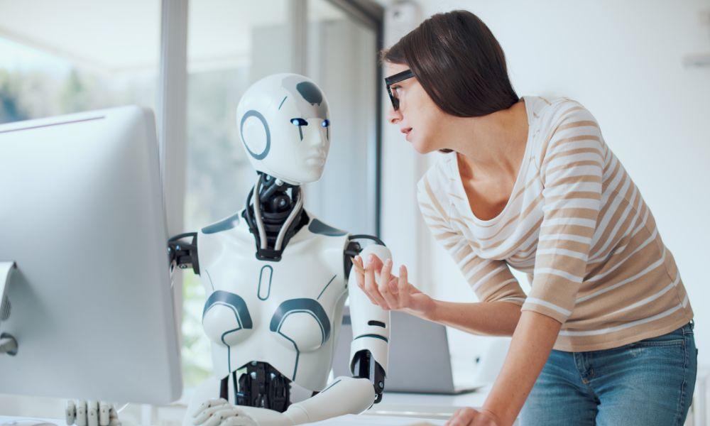 Un robot hablando con una humana en un puesto de trabajo de oficina