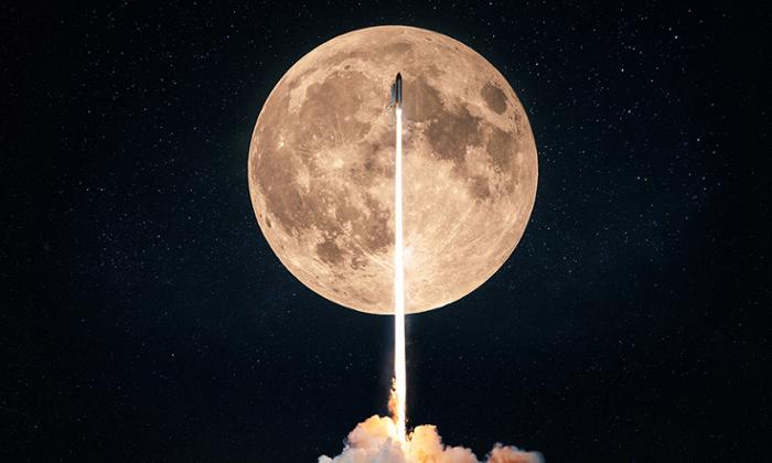Fotografía de un cohete y su estela pasando por delante de una luna llena muy lumninosa
