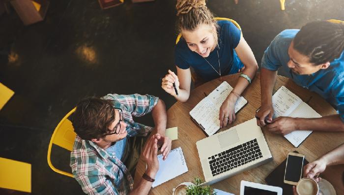 varios jovenes trabajan en grupo en una mesa