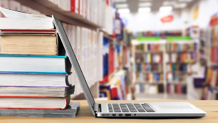 un ordenador portátil apoyado en una pila de libros