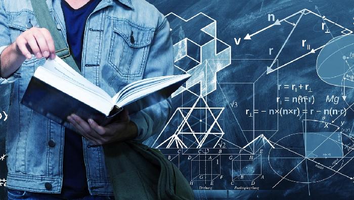 estudiante con un libro delante de una pizarra con fórmulas y signos geométricos