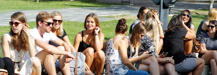 Estudiantes internacionales sentados en el cesped del campus